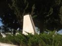 The mass grave with the airplane tail shaped tombstone